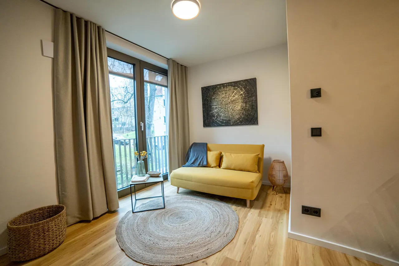 Living area with yellow armchair and floor-to-ceiling window