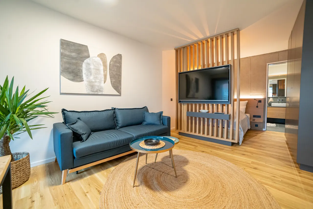 Living room with blue sofa and wooden room divider